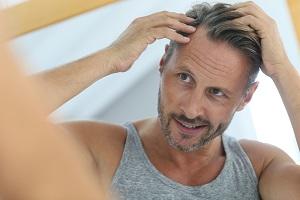 photo-of-a-man-holding-his-head-looking-at-the-mirror.jpg