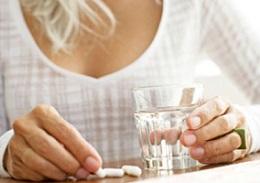 photo-of-a-woman-holding-a-glass-of-water-and-pills.jpg