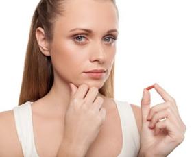 woman-holding-pill-looking-to-camera.jpg