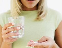 woman-holding-glass-of-water-and-pills.jpeg