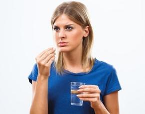 photo-of-a-woman-holding-a-glass-of-water-and-pill.jpg