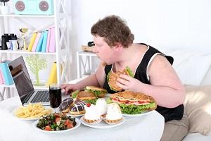 photo-of-obese-man-eating-junk-foods-while-using-laptop.jpg