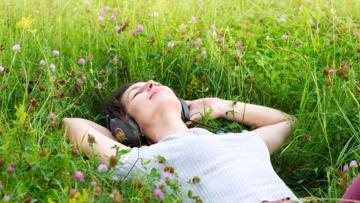 woman-listening-music-lying-on-the-field.jpg