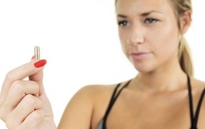 Woman Holding and Staring at Pill