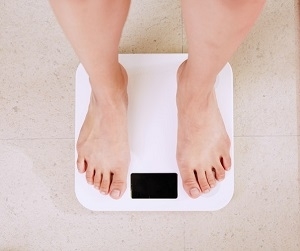 person standing on white digital bathroom scale