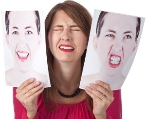 Woman Holding Two Pictures of Her Face